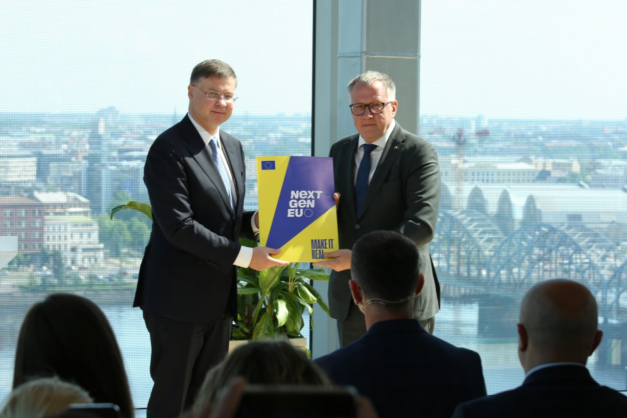 EK priekšsēdētājas izpildvietnieks Valdis Dombrovskis nodod 2. maksājuma mapi finanšu ministram Arvilam Ašeradenam