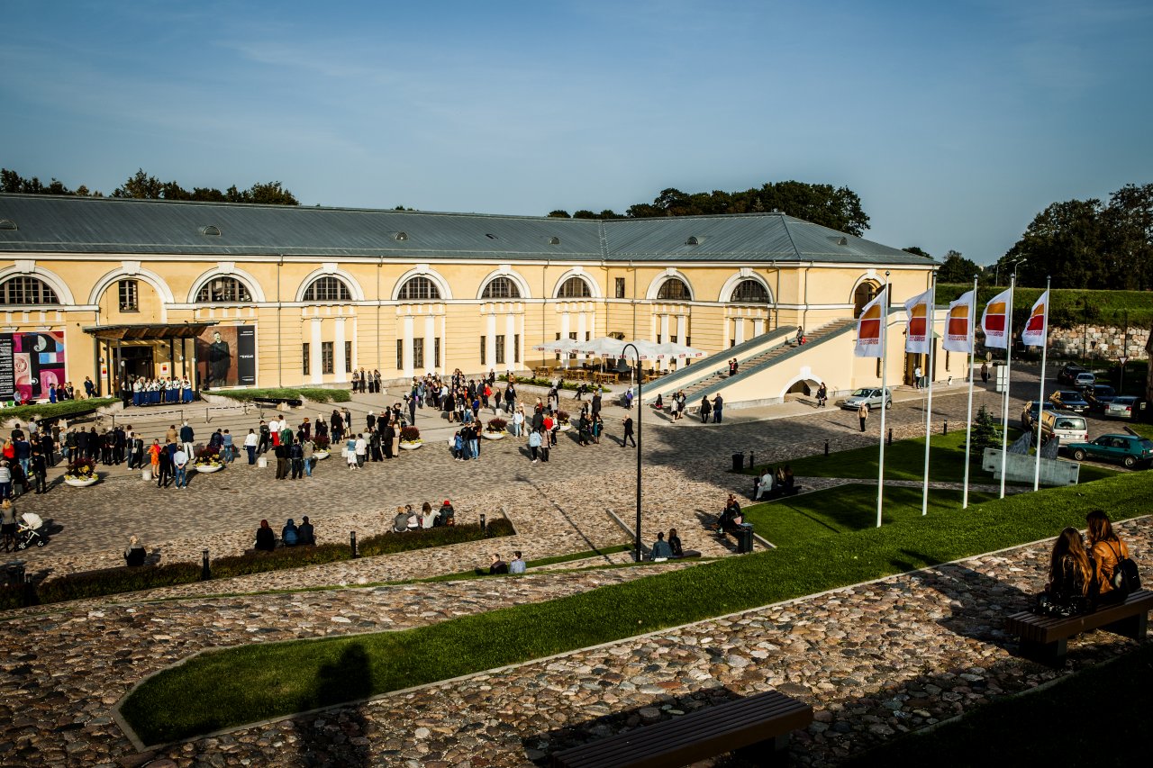 Daugavpils Marka Rotko mākslas centrs, āra pagalms, kurā sapulcējušies cilvēki saulrietā
